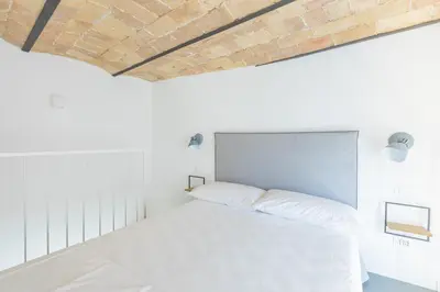 a bed in a white room with a brick ceiling at Mini appartamento Colosseo in Rome