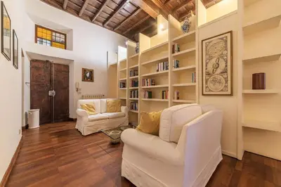 a living room with two white chairs and bookshelves at Unique opportunity to live in a Renaissance palace - AC/WI-FI in Rome