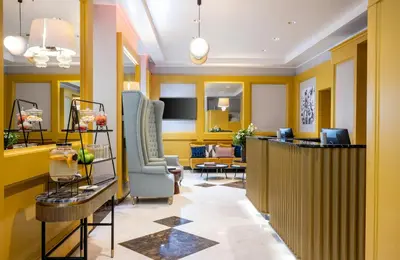 a lobby with yellow walls and a waiting room at Leonardo Boutique Hotel Rome Monti in Rome