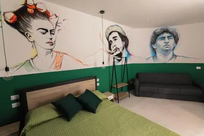 a bedroom with a green bed and a painting on the wall at O.Effe. Suites / Vatican in Rome