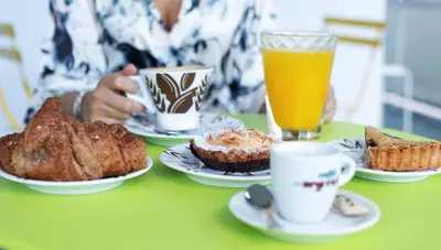 a person sitting at a table with plates of food and drinks at O.Effe. Suites / Vatican in Rome