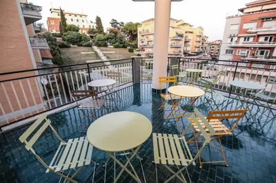 a group of tables and chairs on a balcony at O.Effe. Suites / Vatican in Rome