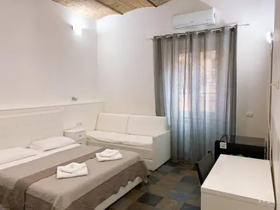 a hotel room with two beds and a couch at Golden Nice in Rome