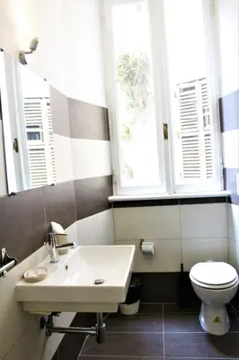 a bathroom with a sink and a toilet and windows at The Castle Inside Rome in Rome