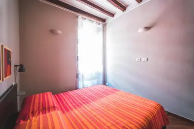a bedroom with a red bed with a window at Colosseum nest in Rome