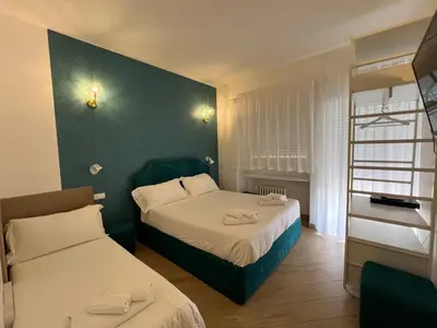 a bedroom with two beds and a green wall at Affreschi al Vaticano in Rome
