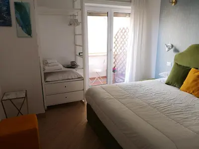 a bedroom with a bed and a door to a balcony at Affreschi al Vaticano in Rome
