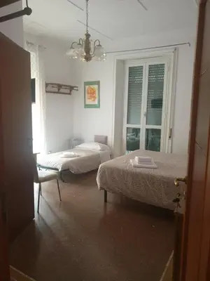 a bedroom with two beds and a window at Chez Liviana in Rome