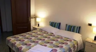 a bed in a room with two tables and two lamps at Chez Liviana in Rome