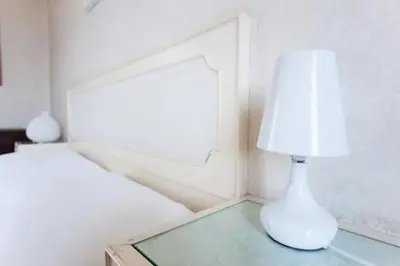 a lamp on a glass table next to a bed at Chez Liviana in Rome