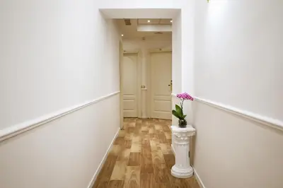 a hallway with a vase with purple flowers in it at Elegant Rooms Roma - Guest House in Rome