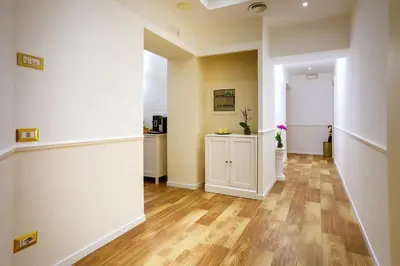 a hallway with white walls and a wooden floor at Elegant Rooms Roma - Guest House in Rome