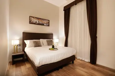 a bedroom with a large bed with white sheets at Elegant Rooms Roma - Guest House in Rome