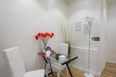 a room with a glass table and two white chairs at La Meraviglia- San Pietro - Vatican Area in Rome