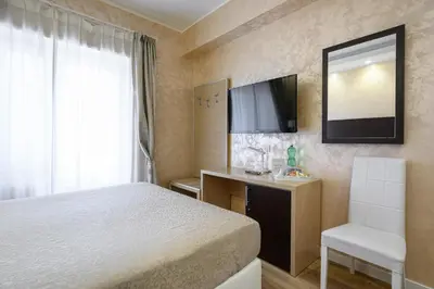 a bedroom with a bed and a desk and a television at La Meraviglia- San Pietro - Vatican Area in Rome