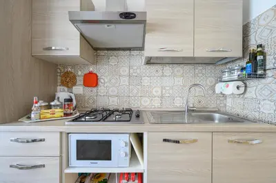 a small kitchen with a sink and a microwave at La Meraviglia- San Pietro - Vatican Area in Rome