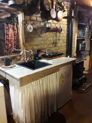 a kitchen with a sink and a stone wall at B&BGarbatella in Rome