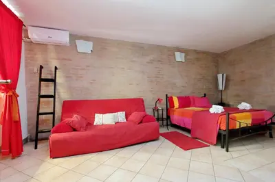 a living room with two beds and a red couch at Lucky Holidays in Rome