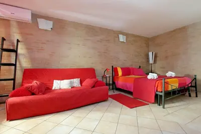 a living room with a red couch and two beds at Lucky Holidays in Rome