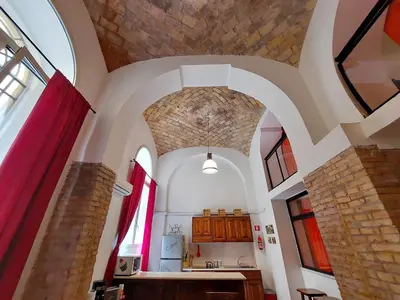 a kitchen with an arched ceiling and a stone wall at Lucky Holidays in Rome