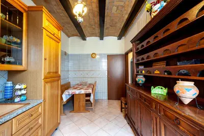 a kitchen with wooden cabinets and a table in it at Kyterion Apartment in Rome