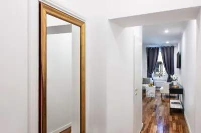 a mirror in a hallway with a living room at Fellini Design Suites in Rome