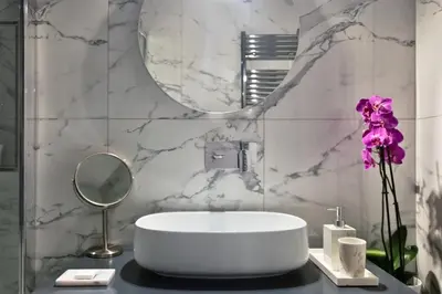 a bathroom with a round sink and a mirror at Fellini Design Suites in Rome