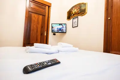 a remote control sitting on top of a bed with towels at La Vite 94 in Rome