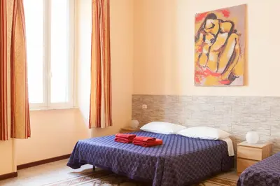 a bedroom with a bed with two red towels on it at Furio Camillo in Rome