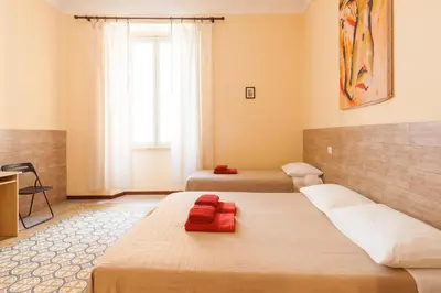 a bedroom with two beds and a large window at Furio Camillo in Rome