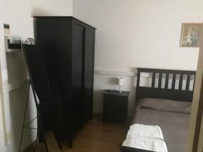 a bedroom with a black cabinet and a bed at Casa per Ferie Suore Domenicane in Rome