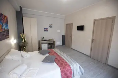 a bedroom with a white bed and a desk at Rooms Monteverde 2 in Rome