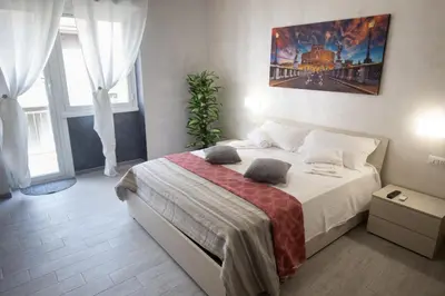 a bedroom with a large bed in a room with windows at Rooms Monteverde 2 in Rome