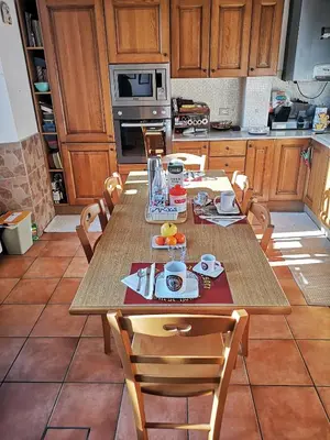 a kitchen with a wooden table with chairs and a tableasteryasteryasteryasteryastery at Vecchia Roma Resort in Rome