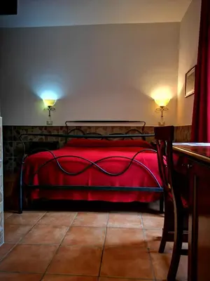 a bedroom with a red bed with two lights on at Vecchia Roma Resort in Rome