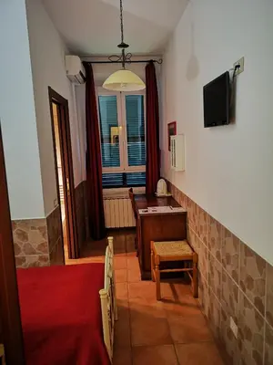a room with a tv and a desk and a window at Vecchia Roma Resort in Rome