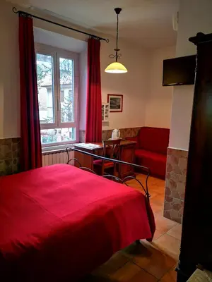 a bedroom with a red bed and a red couch at Vecchia Roma Resort in Rome