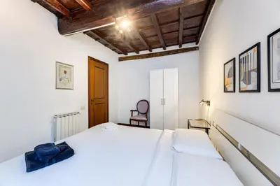 a bedroom with a white bed and a wooden ceiling at Linhouse in Rome