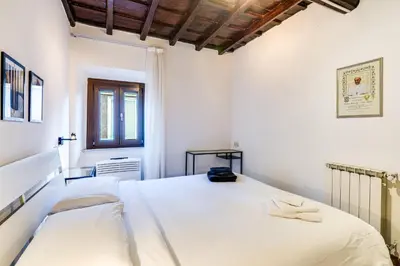 a white bedroom with two beds and a window at Linhouse in Rome