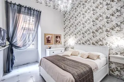 a bedroom with a white bed with a floral wallpaper at Ripetta Miracle Suite in Rome