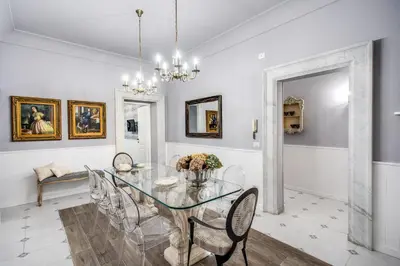 a dining room with a glass table and chairs at Ripetta Miracle Suite in Rome