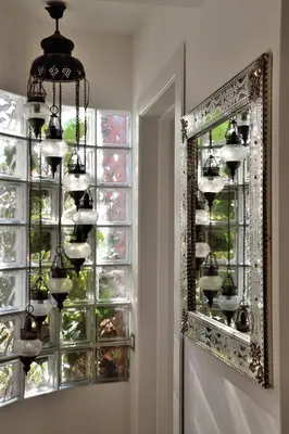a mirror and a chandelier in front of a window at B&B Abbraccia Morfeo in Rome
