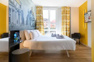 a hotel room with two beds and a window at B&B Hotel Roma San Lorenzo Termini in Rome
