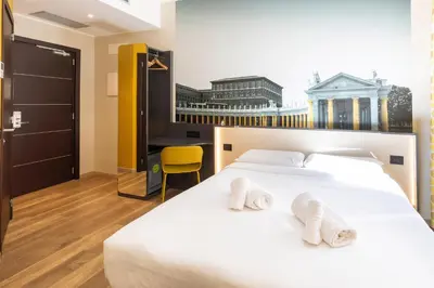 a bedroom with a white bed with two towels on it at B&B Hotel Roma San Lorenzo Termini in Rome