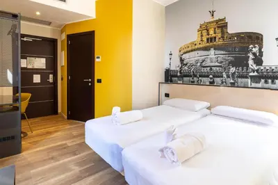 two beds in a room with yellow walls at B&B Hotel Roma San Lorenzo Termini in Rome