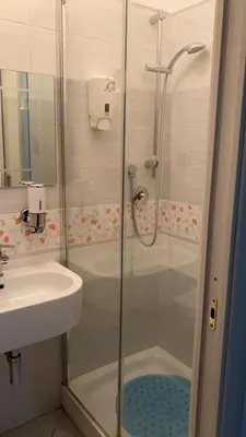 a shower with a glass door next to a sink at Appartamento Remanton in Rome