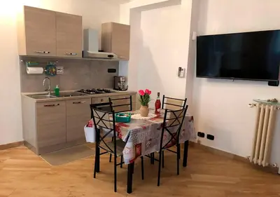 a kitchen with a table with chairs and a television at Appartamento Remanton in Rome