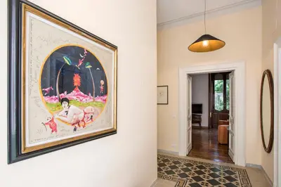 a large painting hangs on a wall in a hallway at Flat Three in Rome