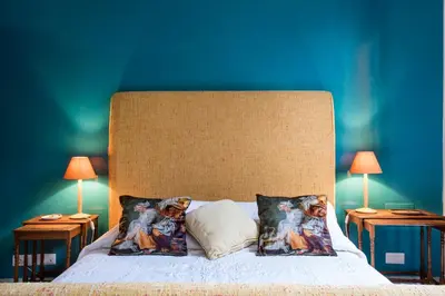 a bed with pillows with a blue wall at Flat Three in Rome