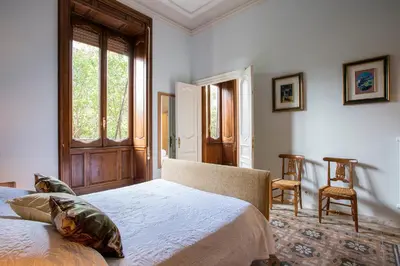 a bedroom with a bed and a window and two chairs at Flat Three in Rome